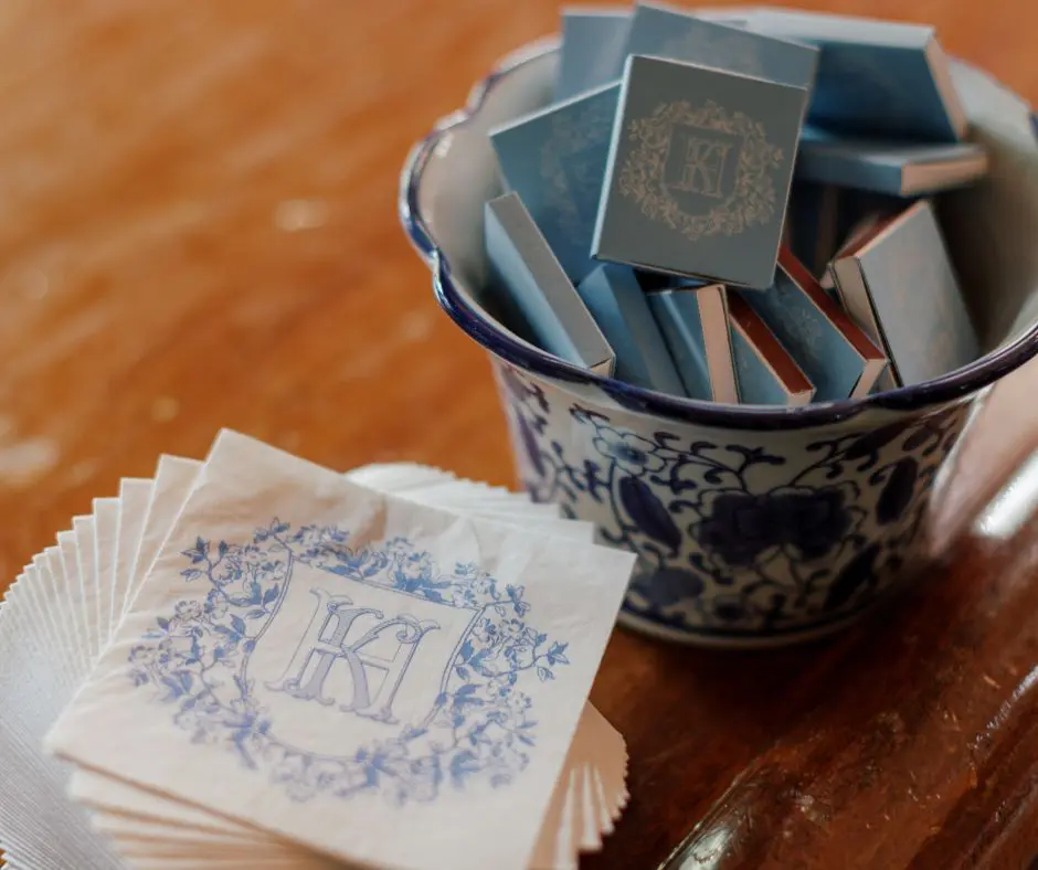 Wedding Favors by Hope Helmuth Stack of customized white and blue napkins next to a jar of blue and white matches
