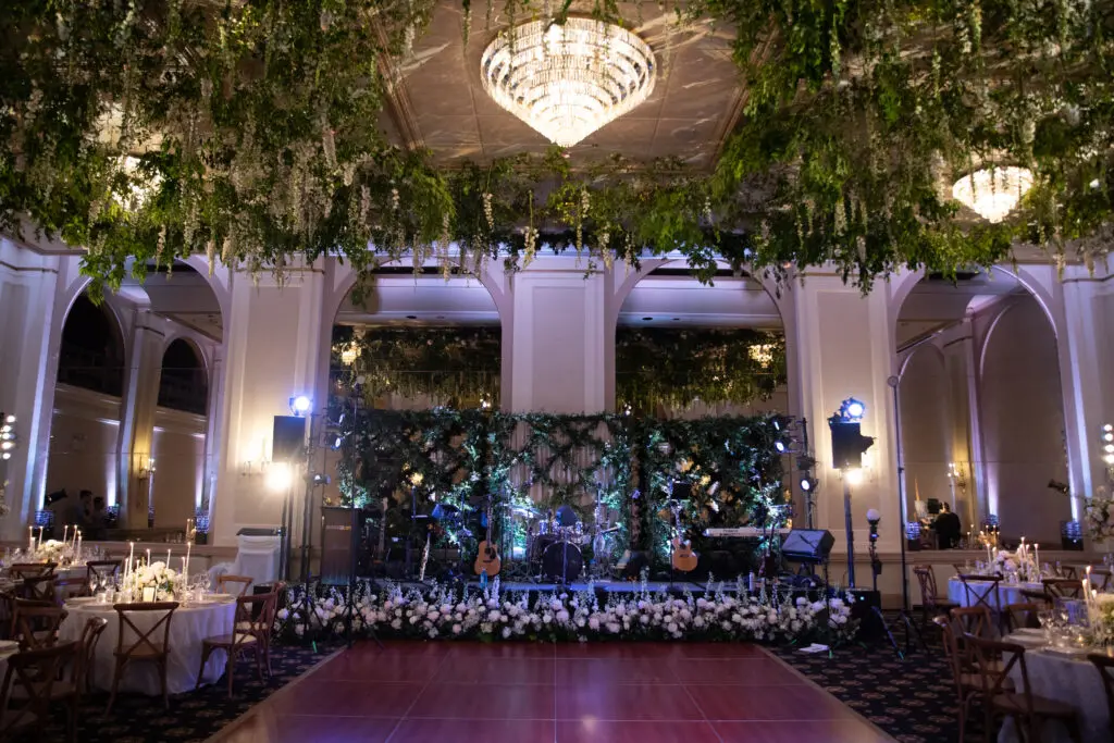 Wedding Band Stage Florals by Tyler Boye Photography Wedding band stage surrounded by white flowers and hanging greenery