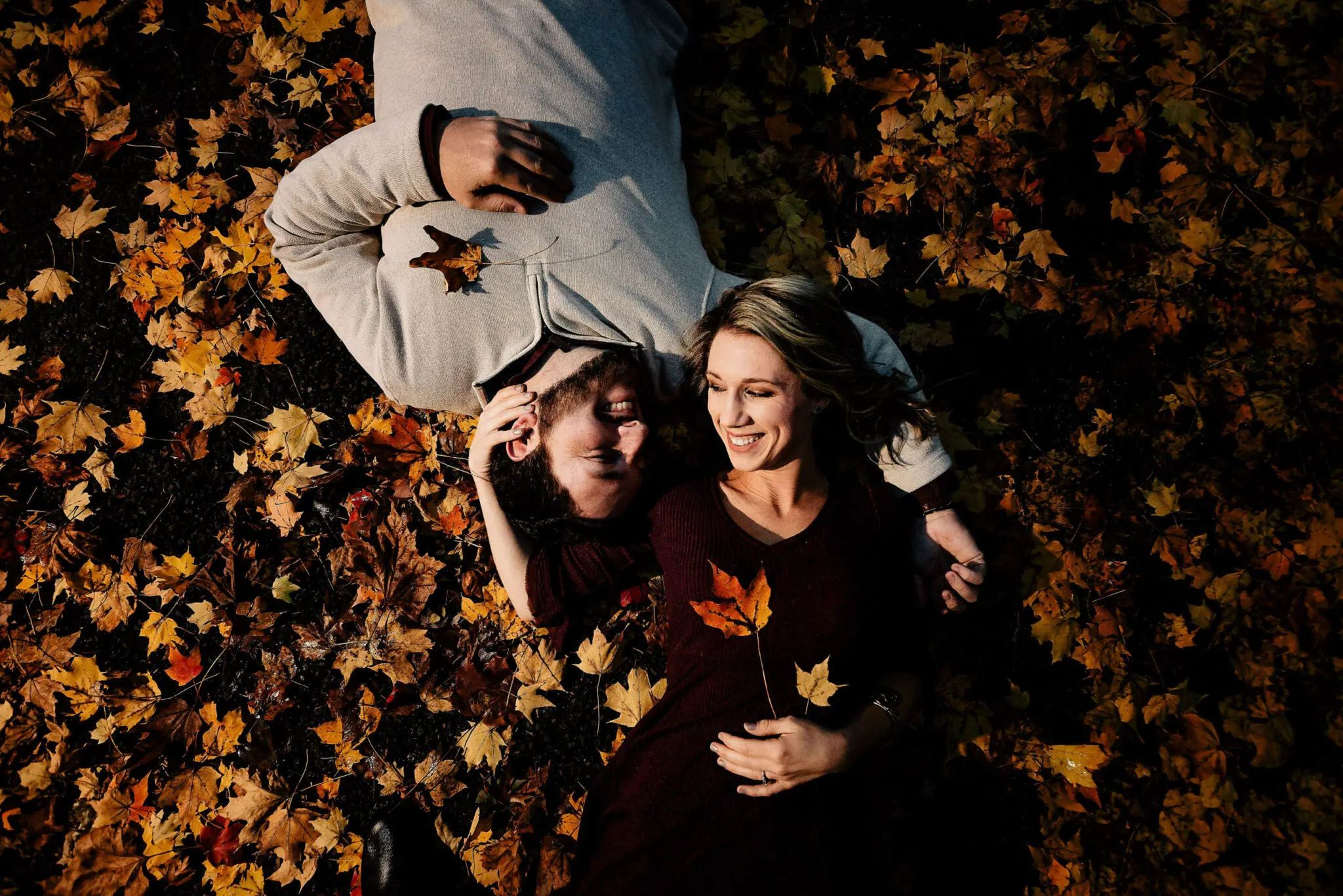 Couple lying in the fall leaves