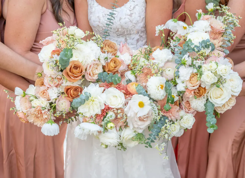 Bridesmaids Florals by Abbe Foreman Photography Bridesmaids and bride in peach dresses holding white and orange bouquets