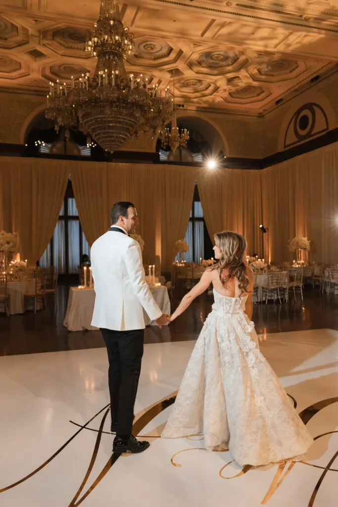 Last Dance Songs for Weddings by Anastasia Romanava Bride and groom holding hands on dancefloor