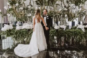 BVTLive! Wedding at The Four Seasons Hotel by M2 Photo Bride and groom standing in front of botanical display at the Four Seasons Hotel