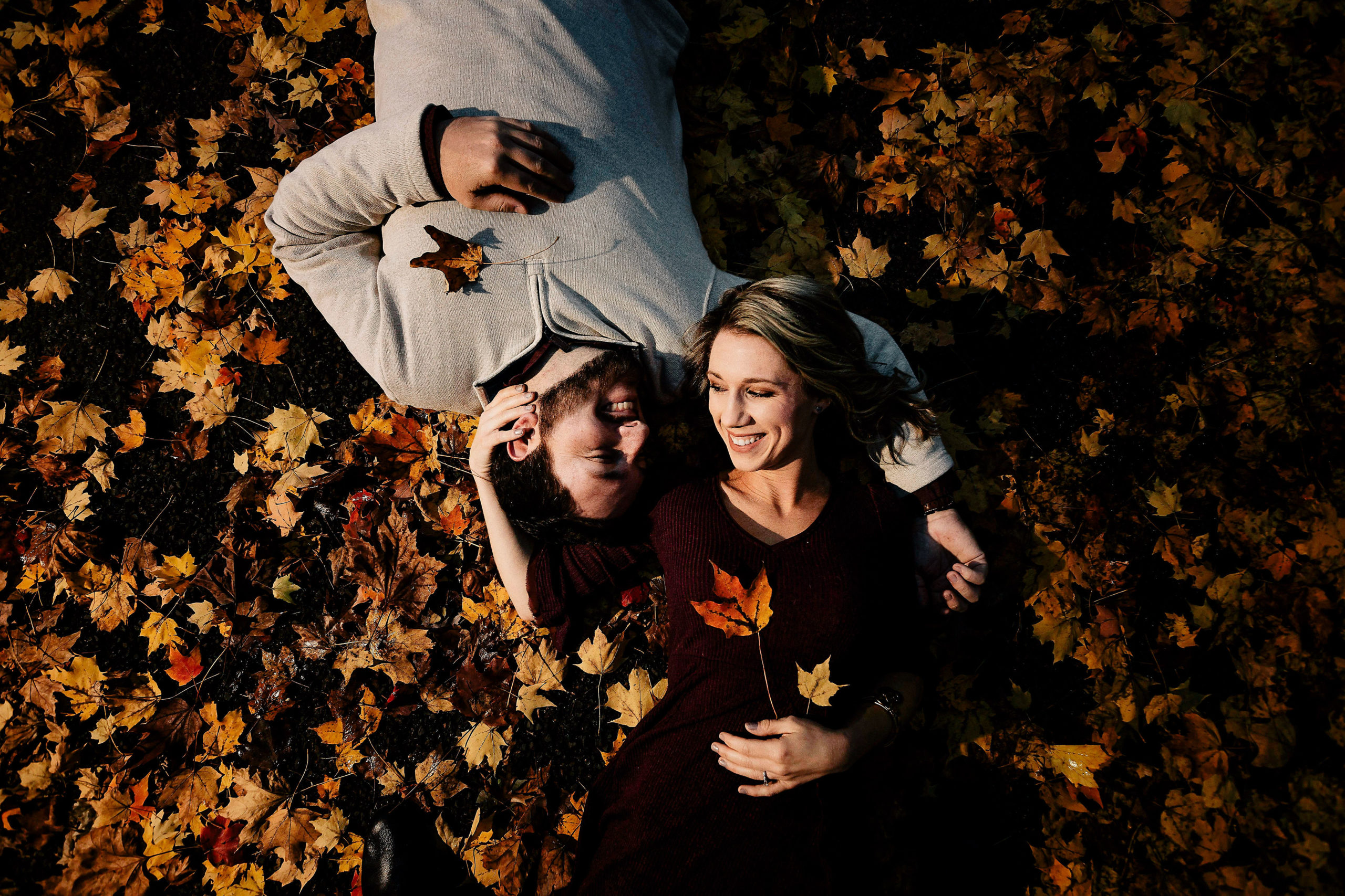 Couple lying in the fall leaves