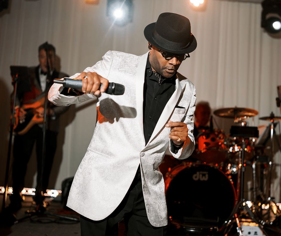 Lead vocalist of Jellyroll Band dancing as he holds microphone mid-song