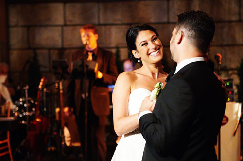 A beautiful bride and handsome groom smile as they share a first dance with a serenade from the City Rhythm band.